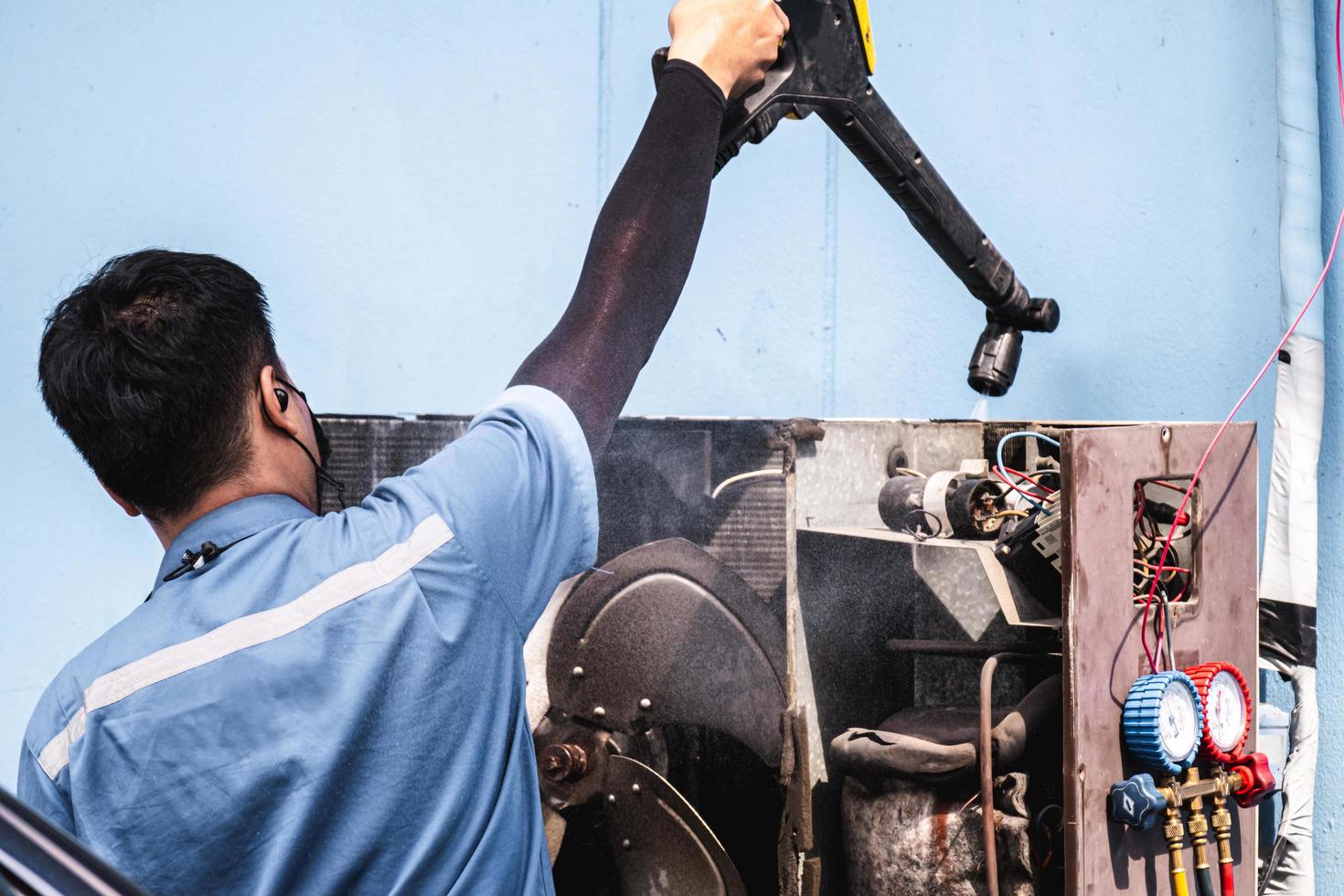 Bangkok Thailand - June 23, 2021. Asian man is using a high-pressure cleaner to skillfully exhaust the air compressor. photo