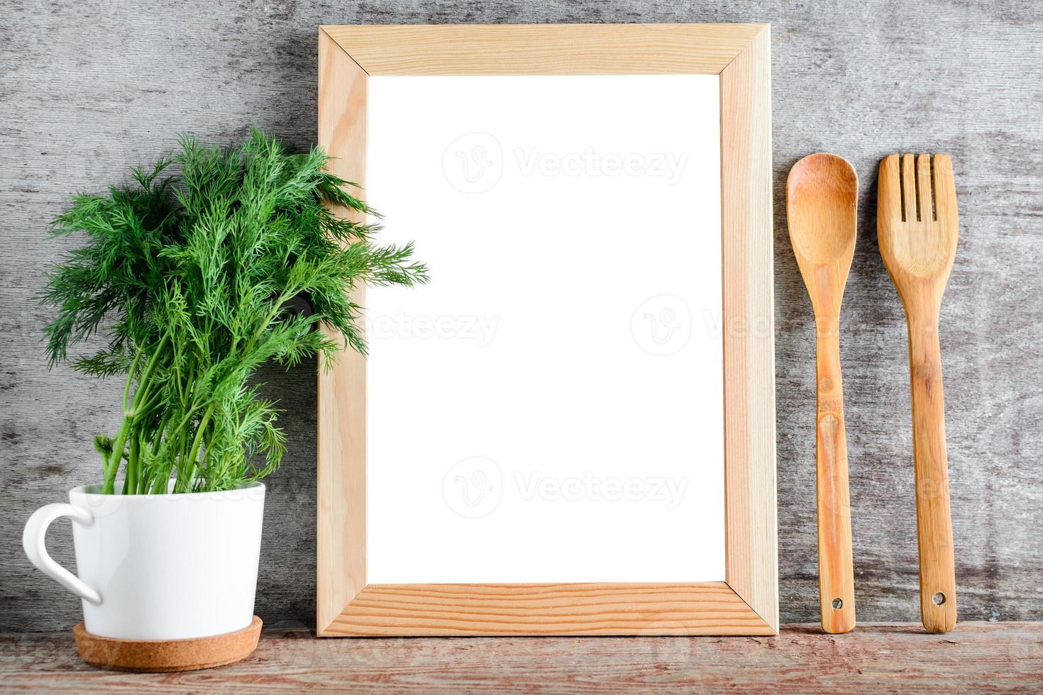 un marco de madera vacío y accesorios de cocina en una pared gris. foto