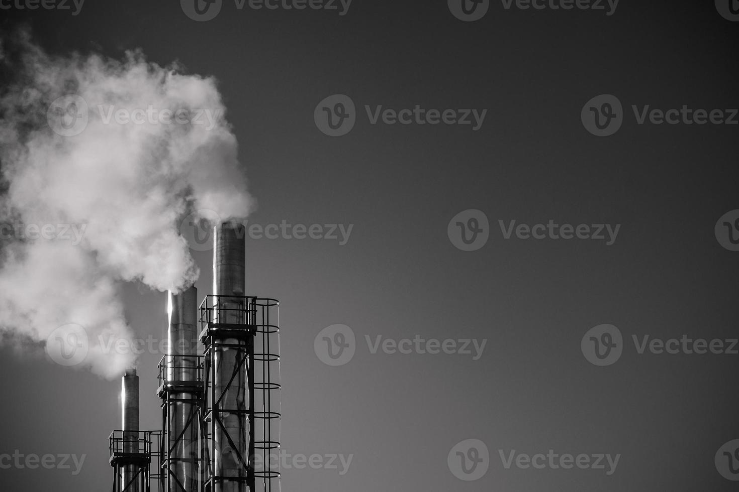 tres pipas de una planta contra el cielo. el concepto de contaminación ambiental. foto