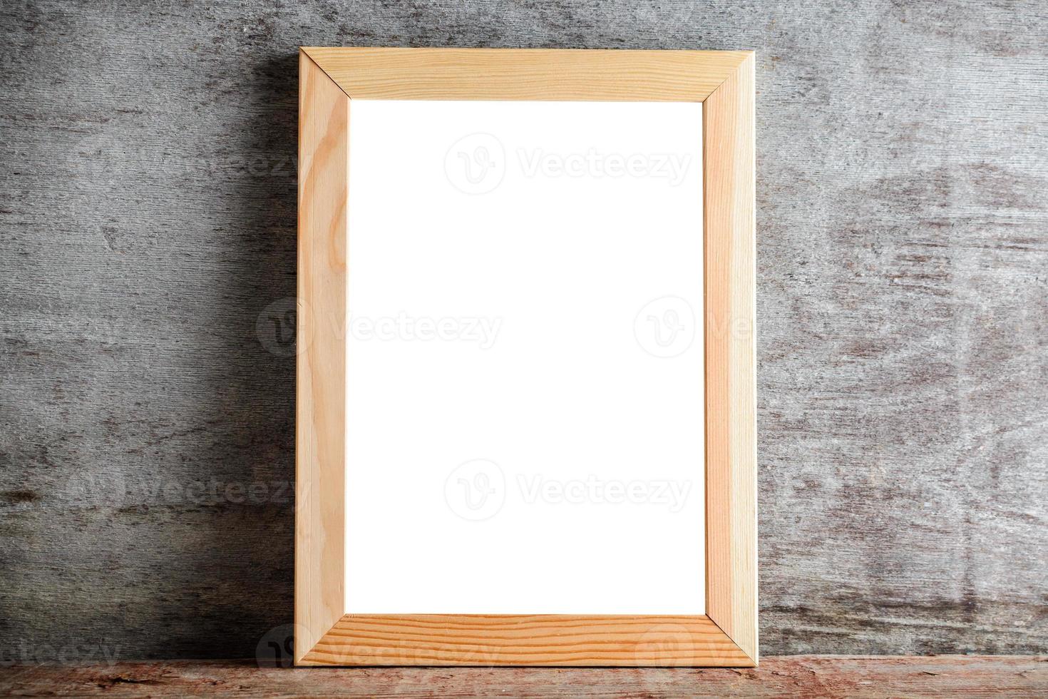 wooden frame on a wooden table on a gray wall. Template layout for adding a design or an inscription photo