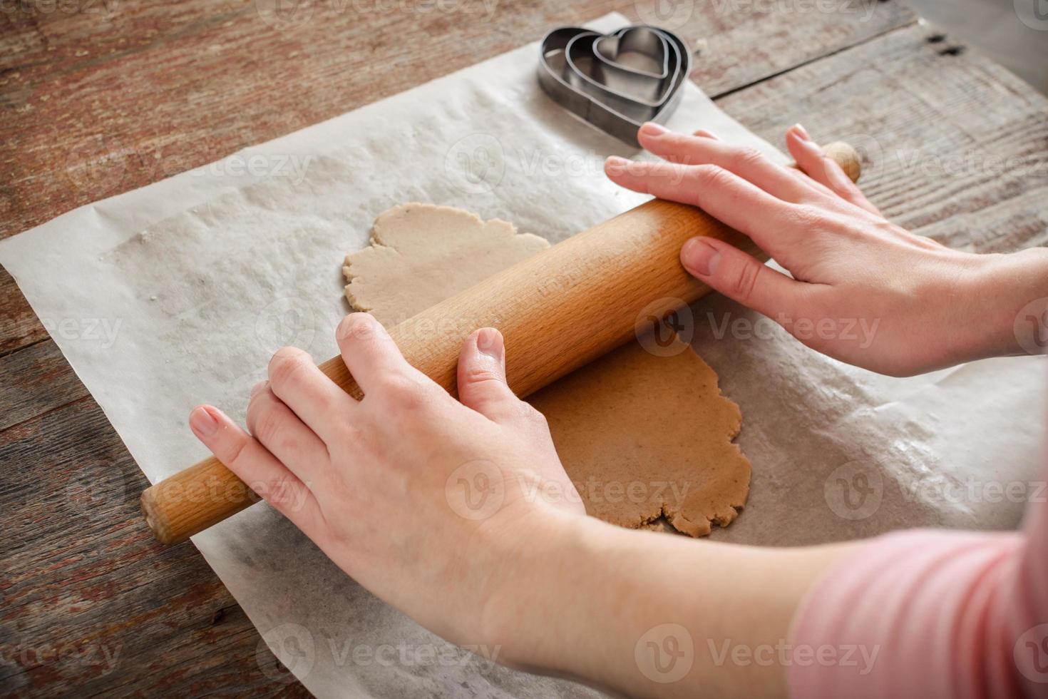 una mujer joven está cocinando galletas de jengibre caseras. foto