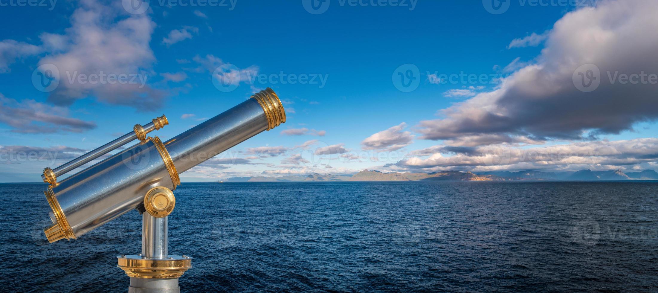 Banner with an old telescope looking towards dreams and adventures, at blue sky and ocean, with copy space for text. Concept travel, freedom and adventure, nomadic lifestyle. photo