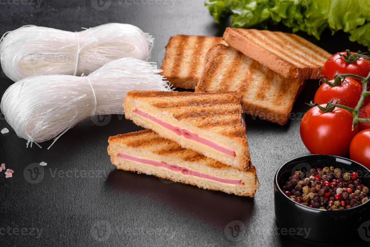 Sandwich with ham, cheese, tomatoes, lettuce, and toasted bread photo