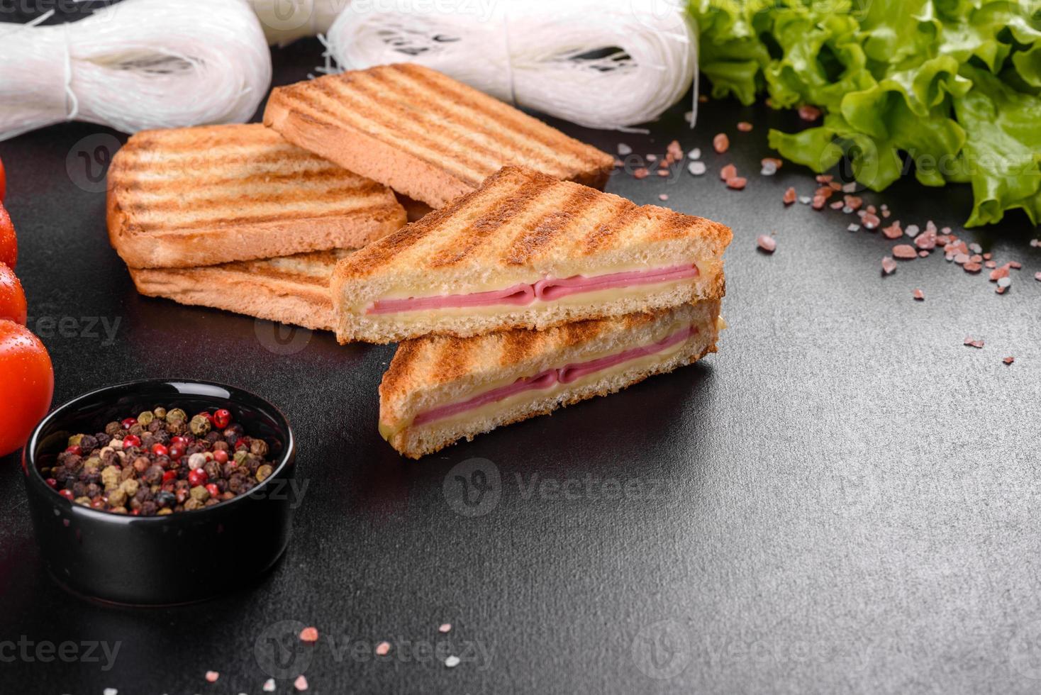 Sandwich with ham, cheese, tomatoes, lettuce, and toasted bread photo