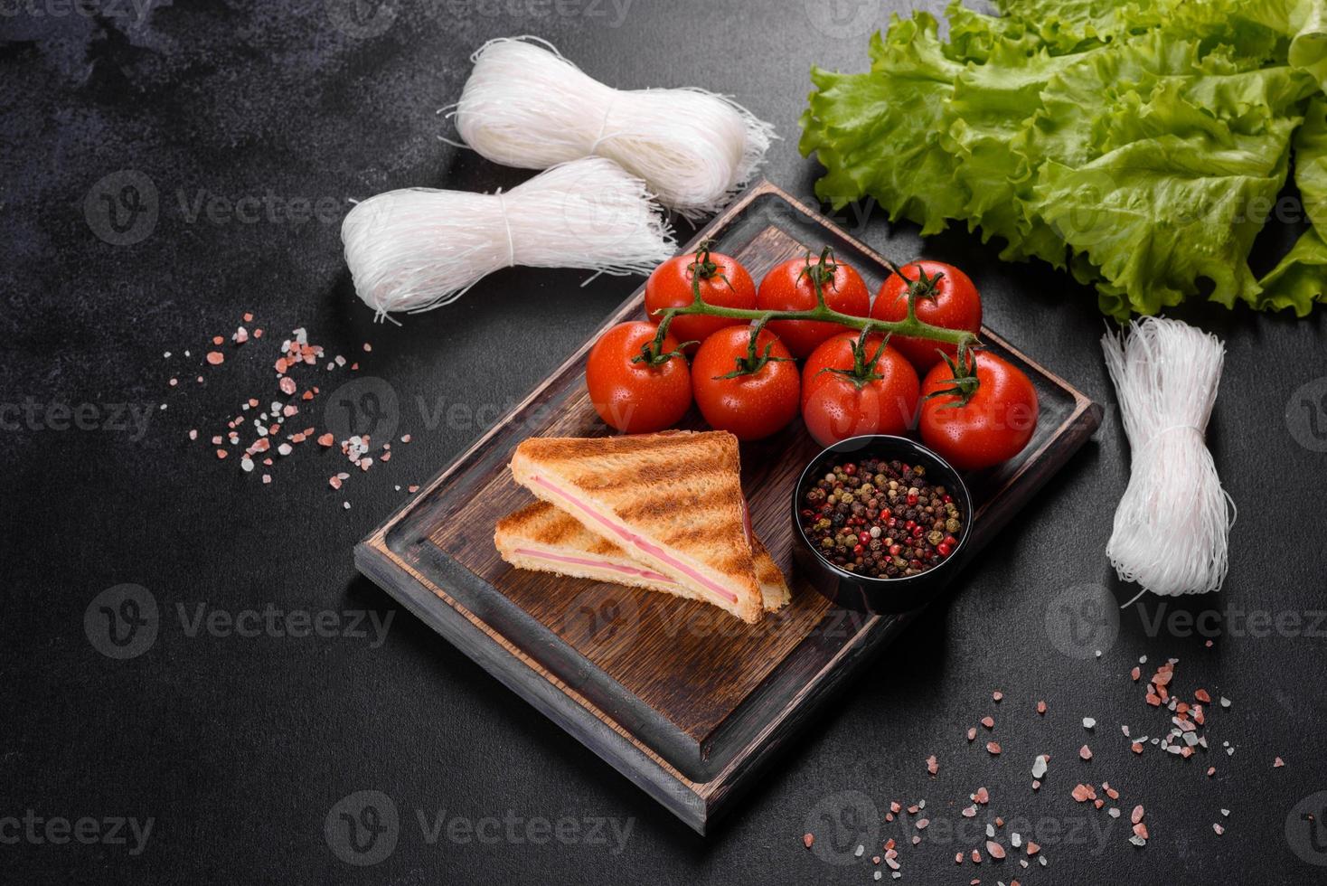 Sandwich with ham, cheese, tomatoes, lettuce, and toasted bread photo