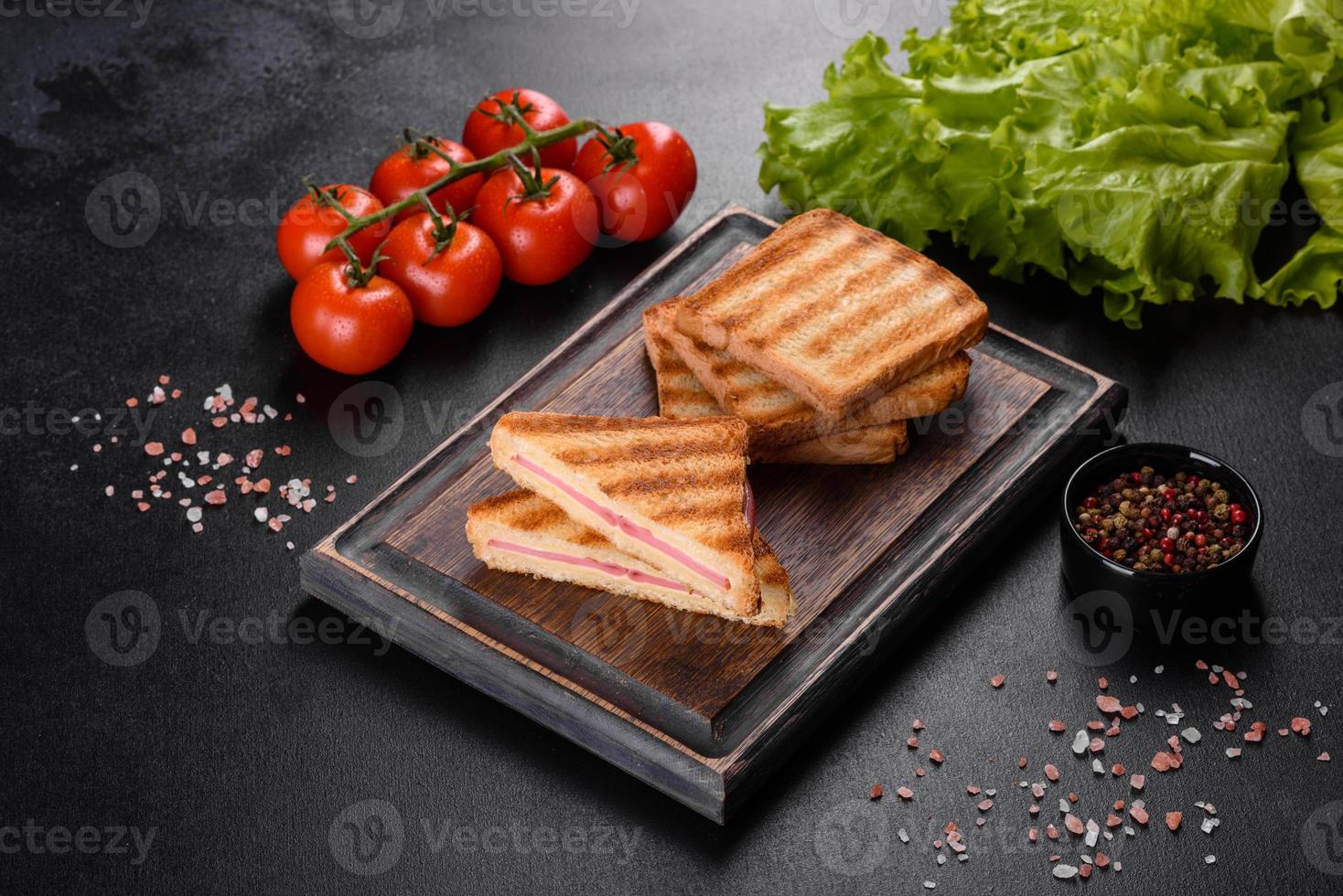 Sandwich with ham, cheese, tomatoes, lettuce, and toasted bread photo