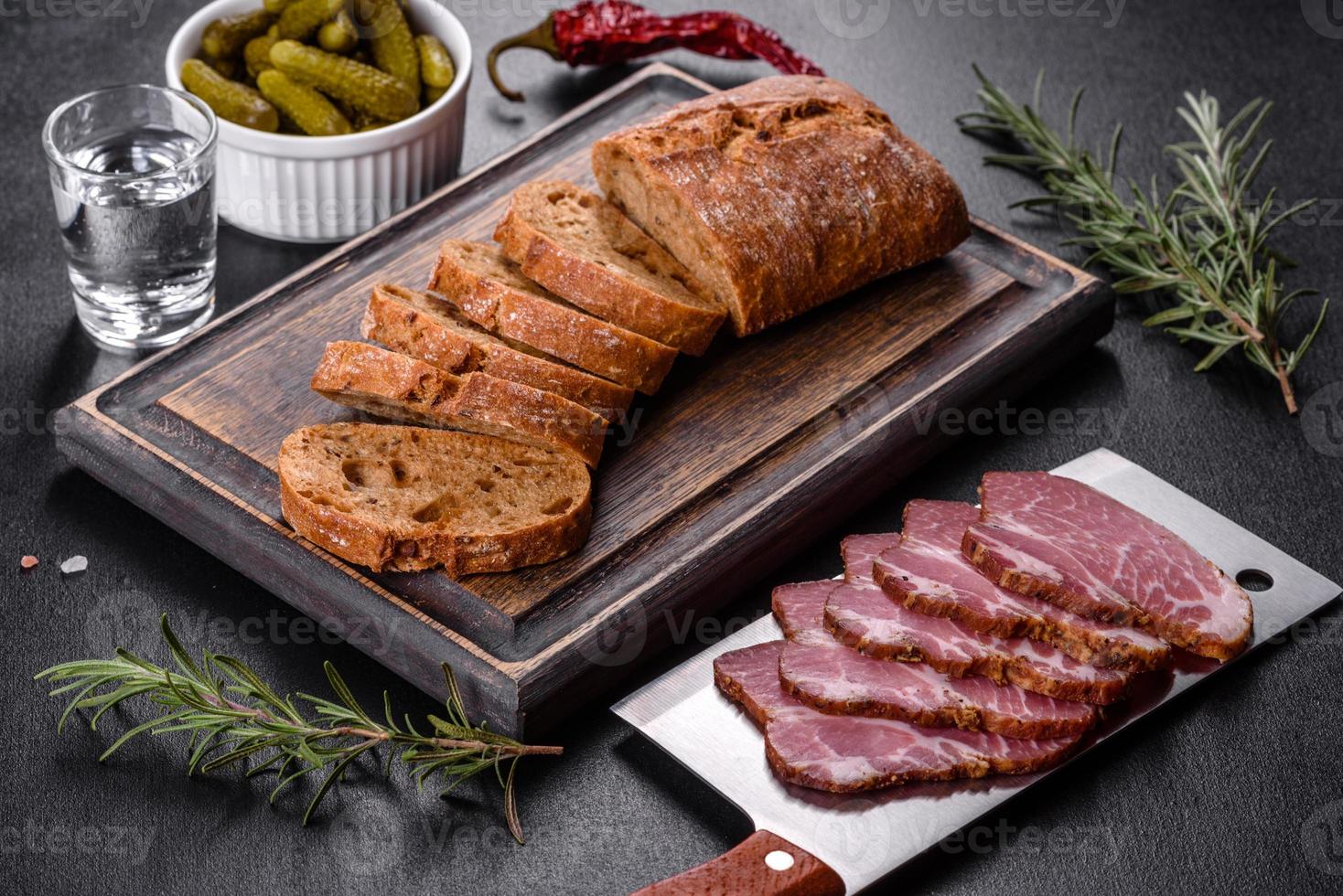 delicioso tocino fresco rebanado con pan y verduras foto