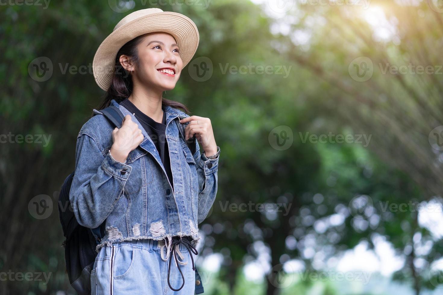 Young Asian woman explores the forest on holiday photo