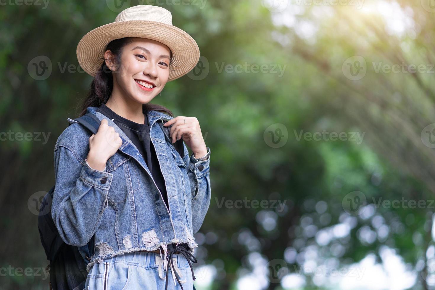 joven asiática explora el bosque de vacaciones foto