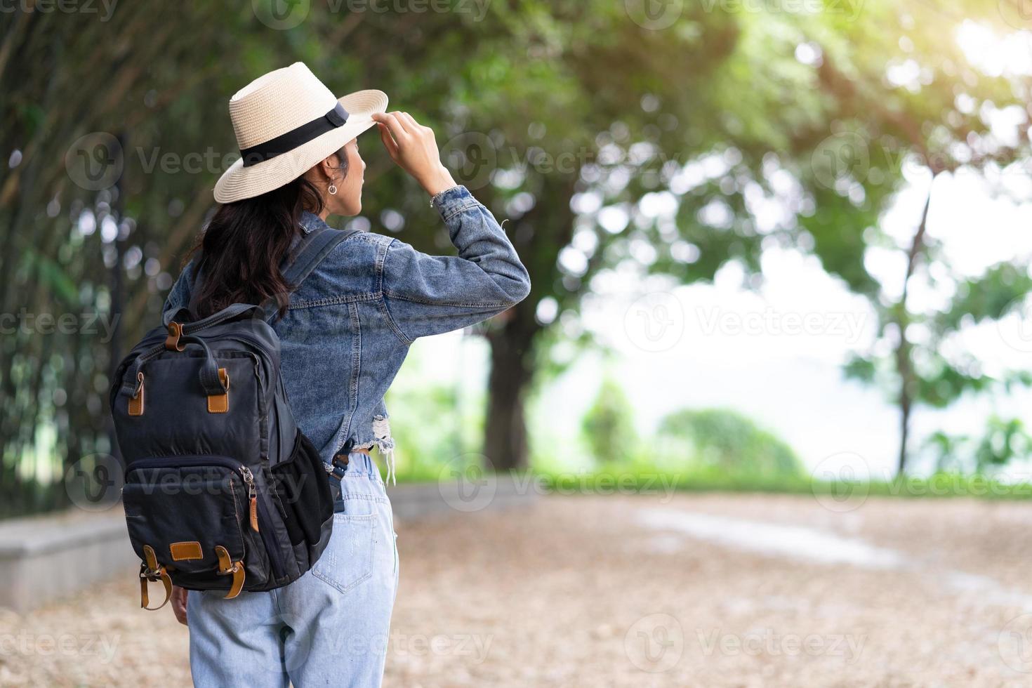 Young Asian woman explores the forest on holiday photo