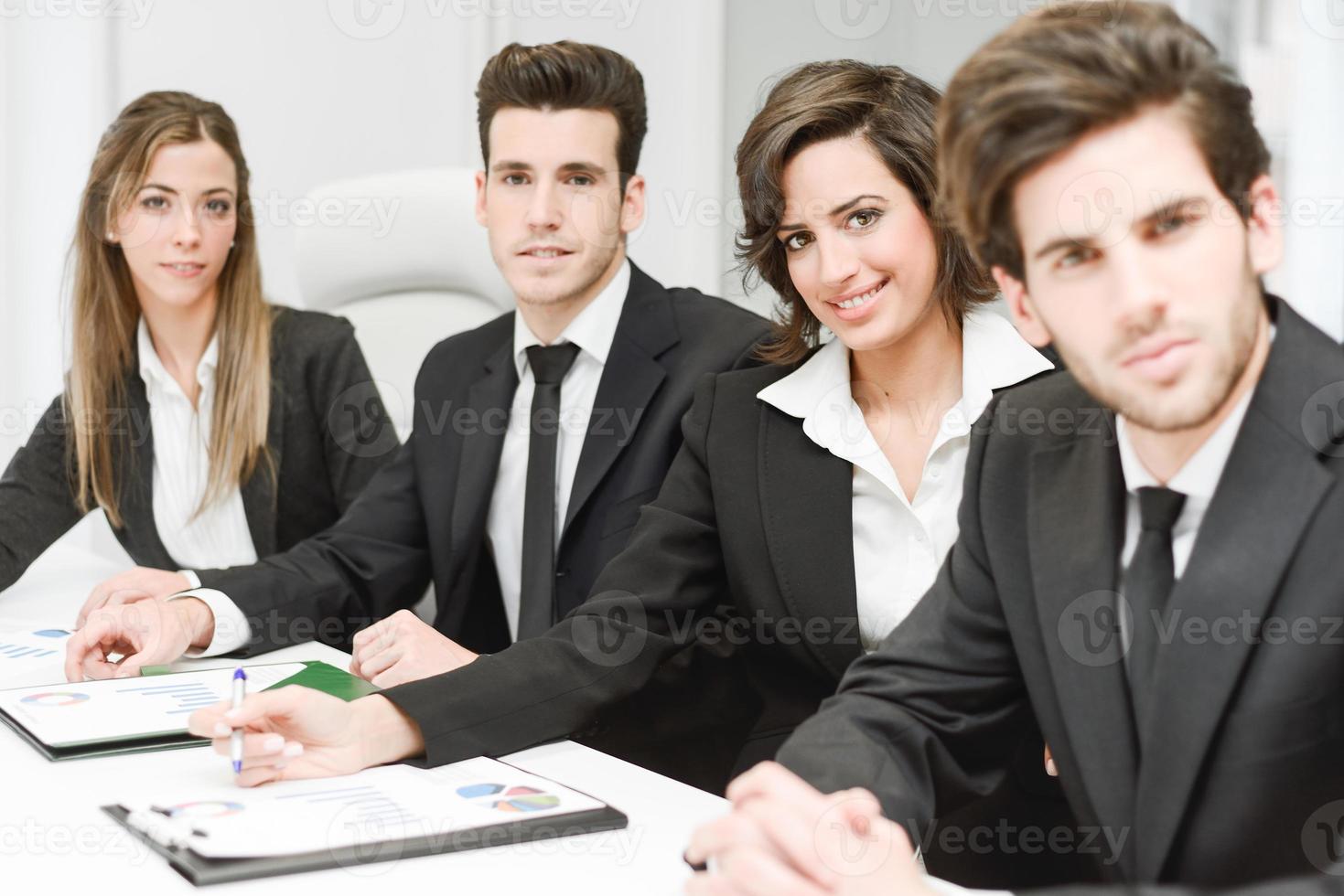 Business team looking at camera in working environment photo