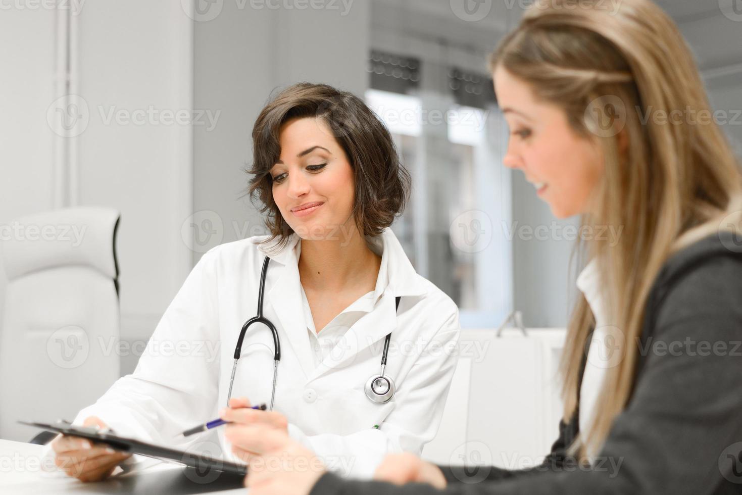 Doctor explaining diagnosis to her female patient photo