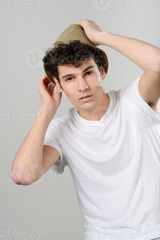 Handsome young man with hat on white background photo