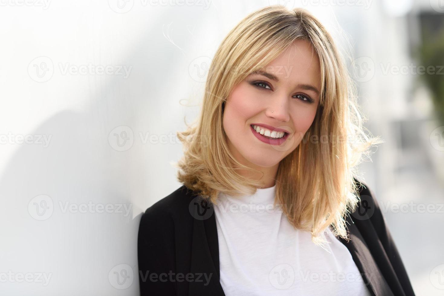 Beautiful young blonde woman in urban background photo
