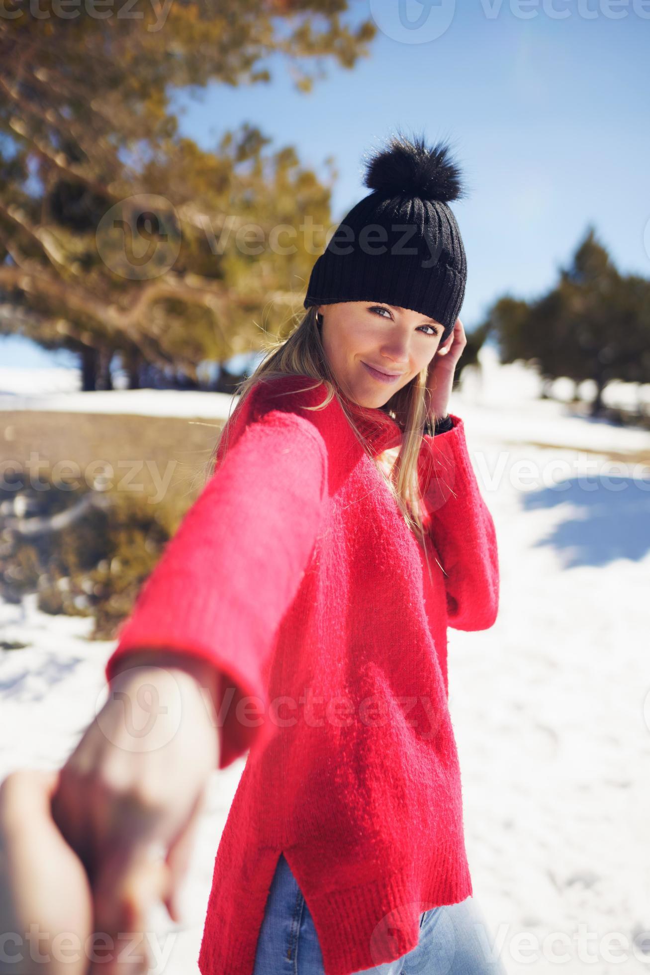 Blonde woman in winter clothes walking holding her partner's hand in the  snowy mountains. 4241599 Stock Photo at Vecteezy