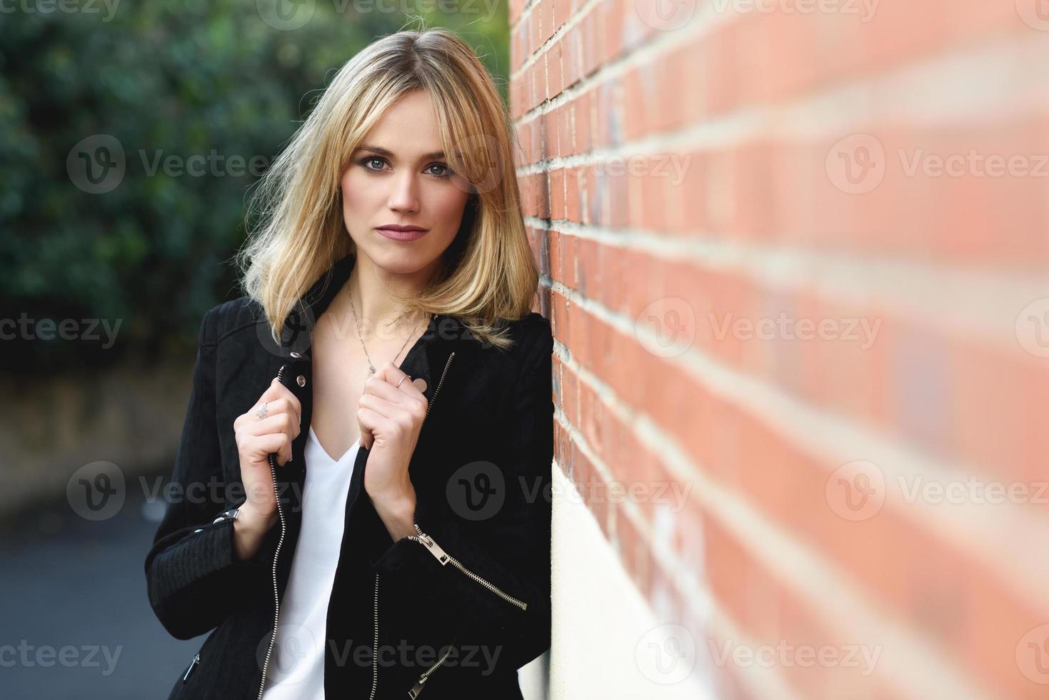 hermosa joven rubia en el fondo urbano foto