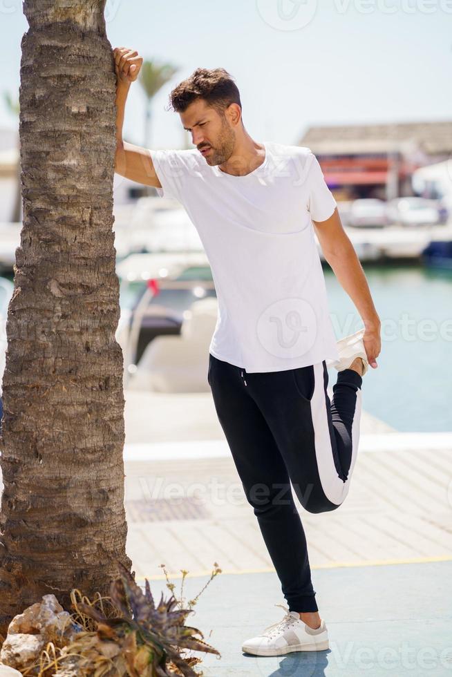 Man stretching after exercise in a harbour photo