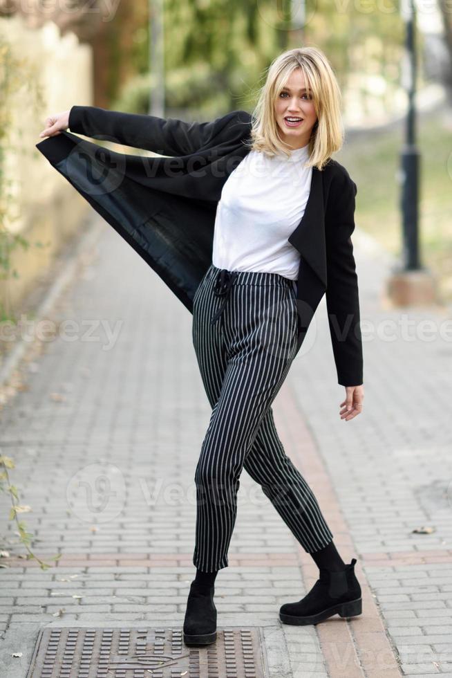 Beautiful young blonde woman in urban background photo