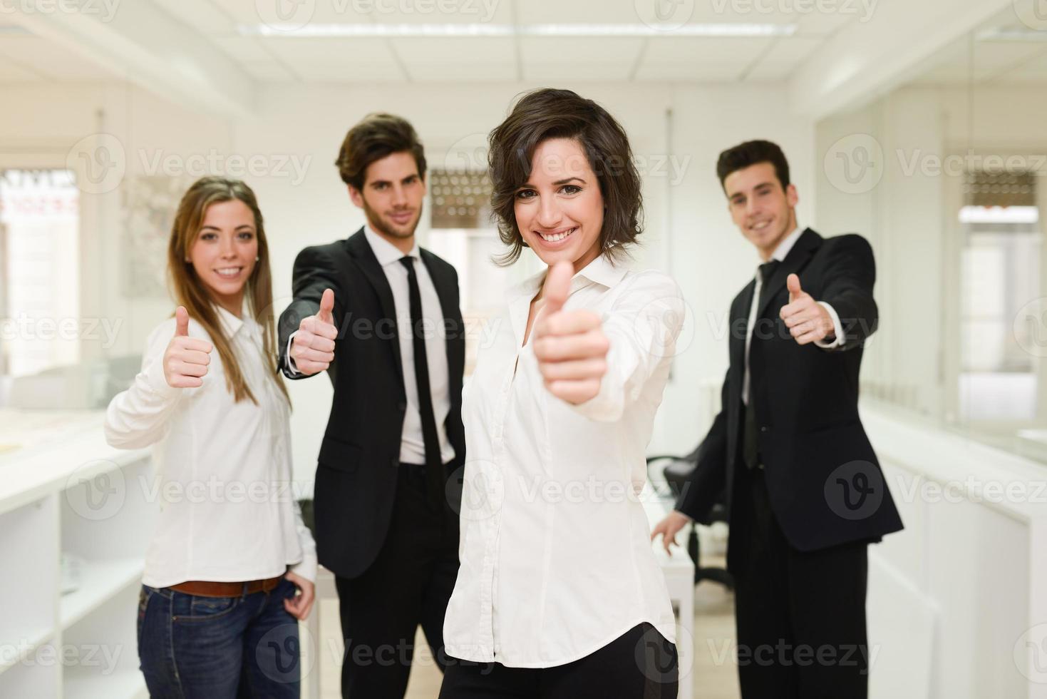 Cheerful business group giving thumbs up photo