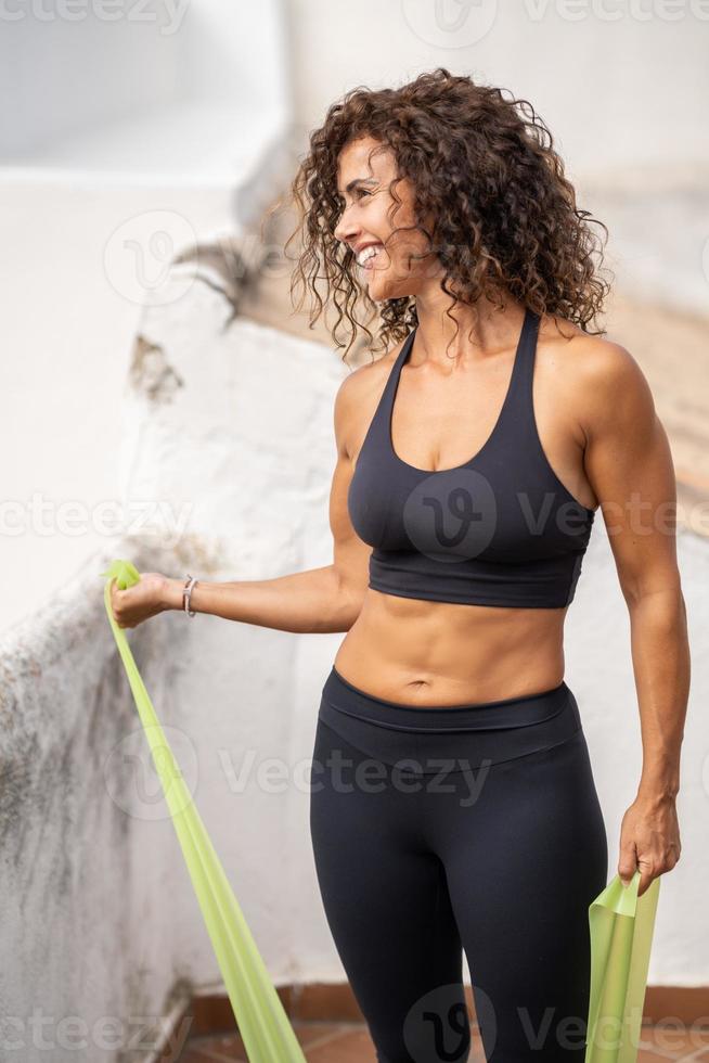 Mujer de mediana edad con cuerpo fitness trabajando en la terraza de su casa foto