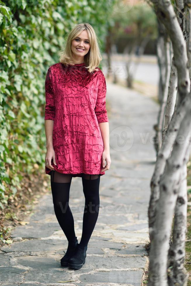 Hermosa joven rubia sonriendo en el fondo urbano foto