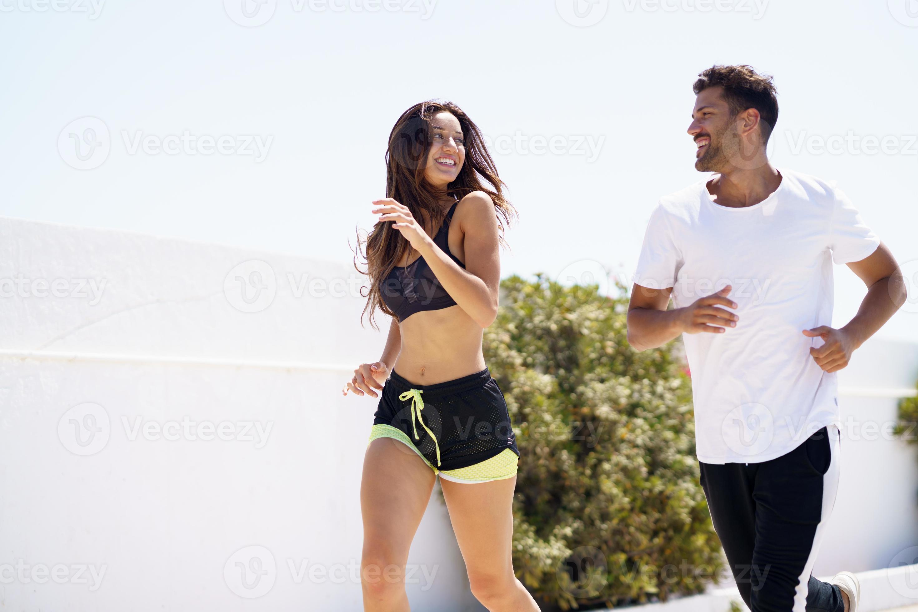 Young beautiful couple training together running outdoors photo