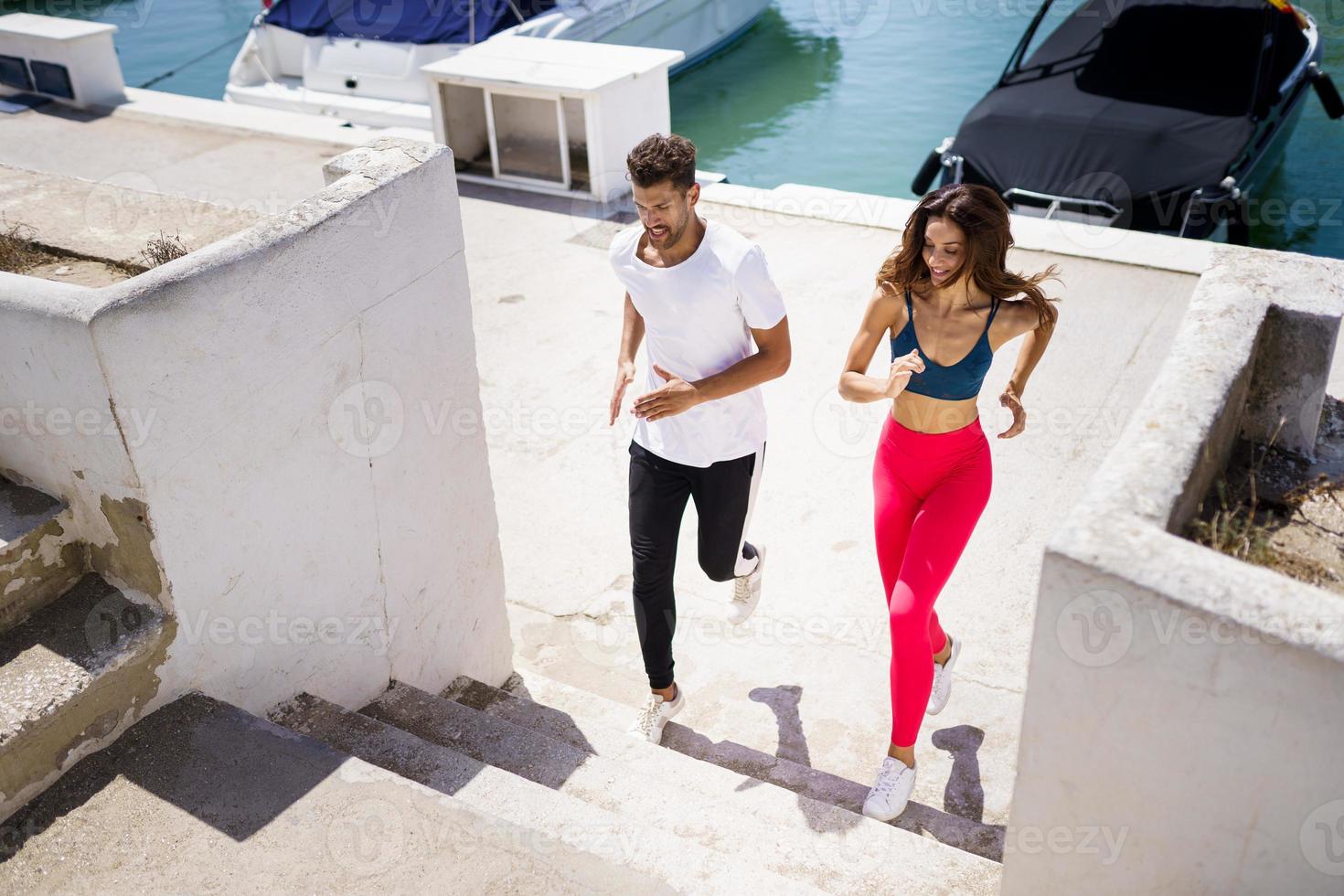 pareja atlética entrenando duro subiendo escaleras juntos al aire libre. foto