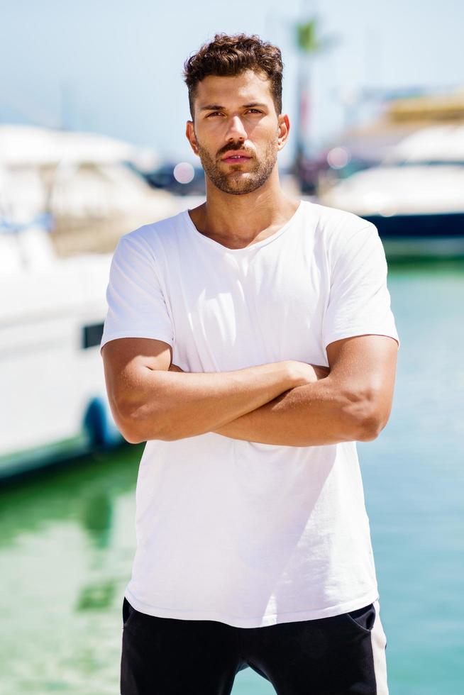 Fitness model in sportswear outfit posing on waterfront harbour. photo