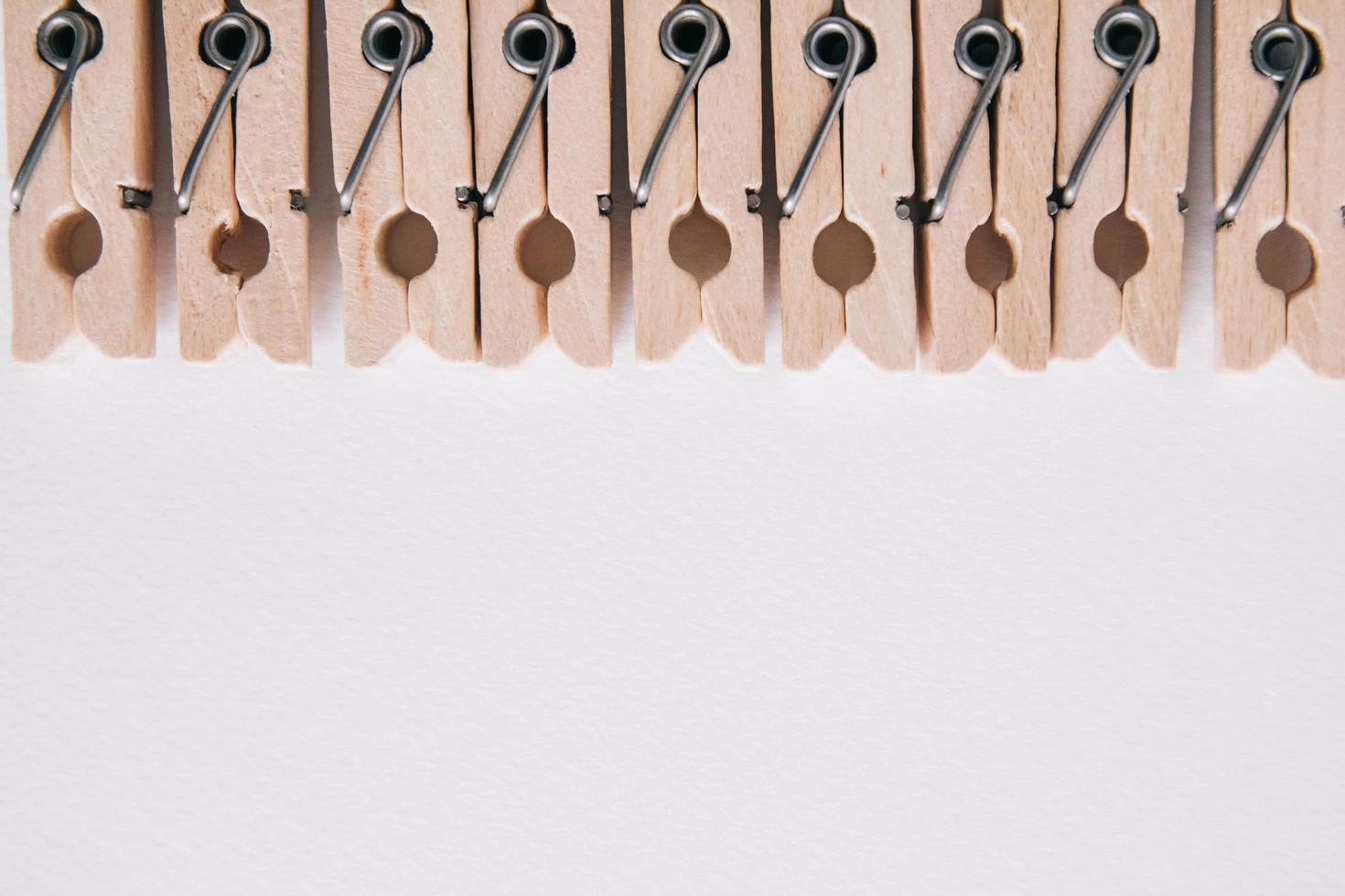 Wooden clothespins on a white background. View from above. Place for text or advertising photo