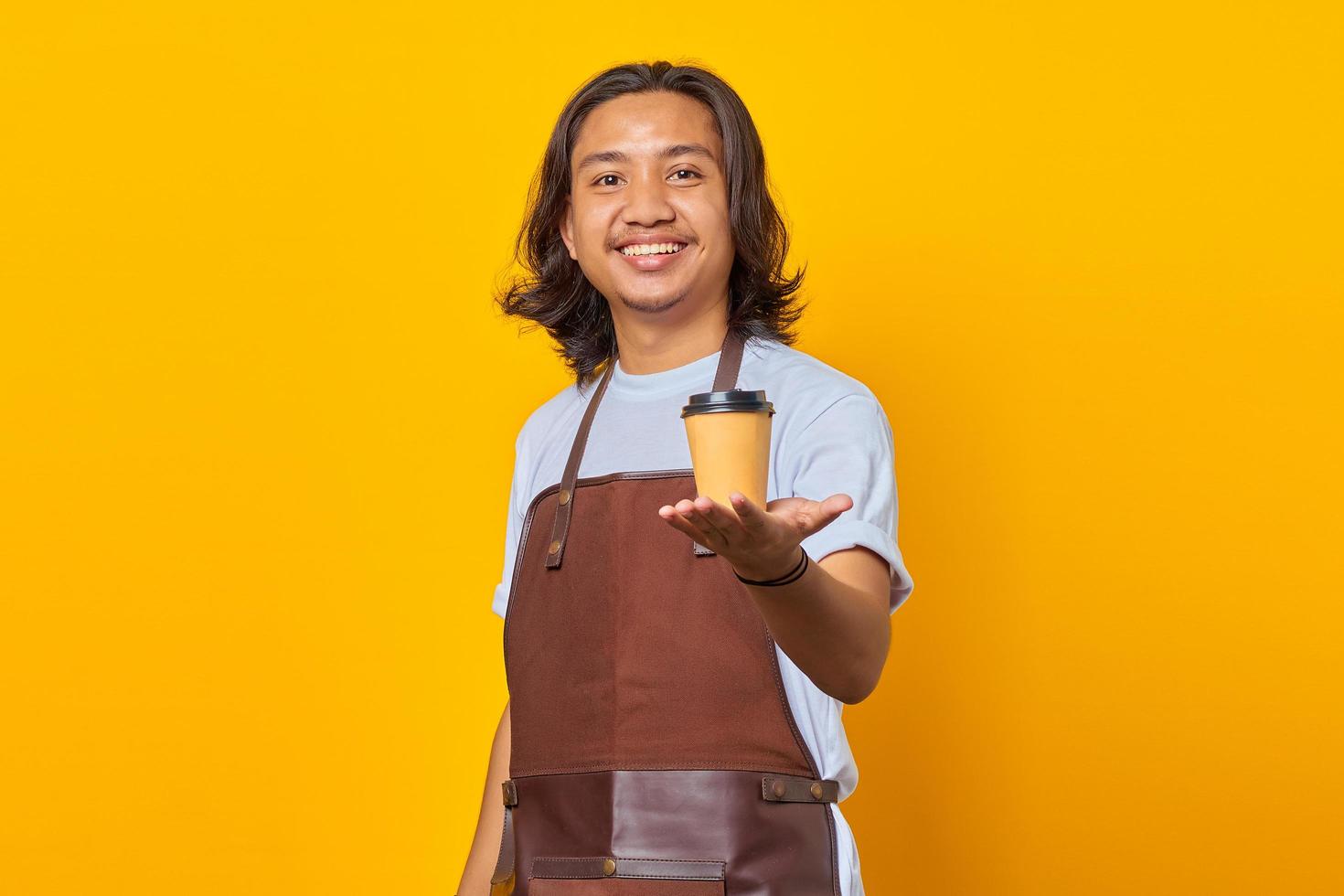 Retrato de hombre guapo alegre y positivo sosteniendo un vaso de papel con las manos recomendándole que deguste el tipo de café foto