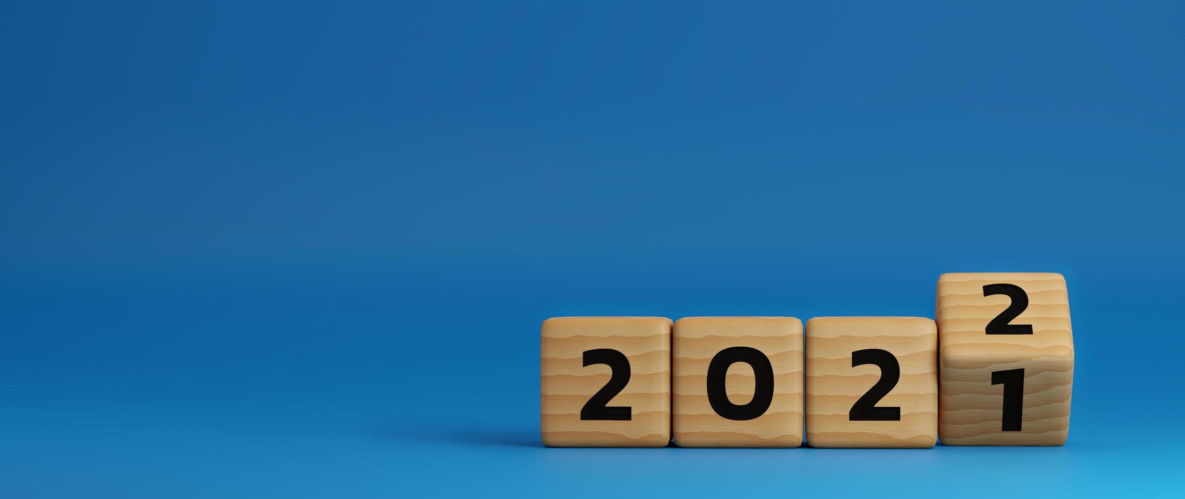 comienzo al año 2022. bloque de cubo de madera volteando para cambiar el año 2021 al año 2022 sobre fondo azul con espacio de copia. concepto de feliz año nuevo. Ilustración de render 3d. foto