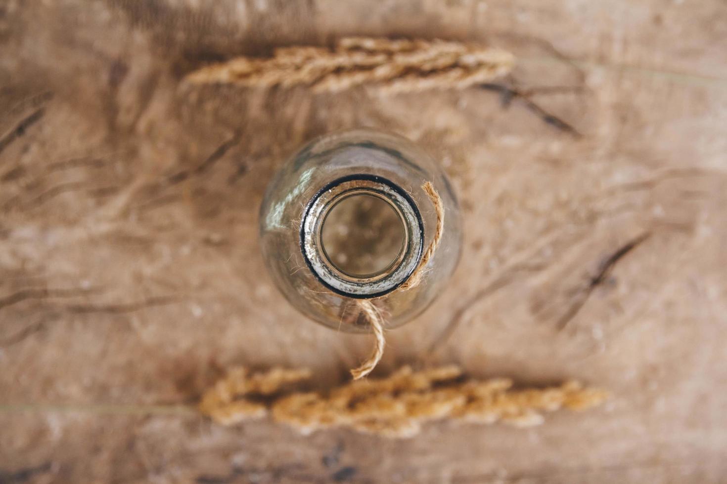 Still life of a bouquet of dried flowers in a glass bottle on a wooden table. Place for text or advertising. View from above photo