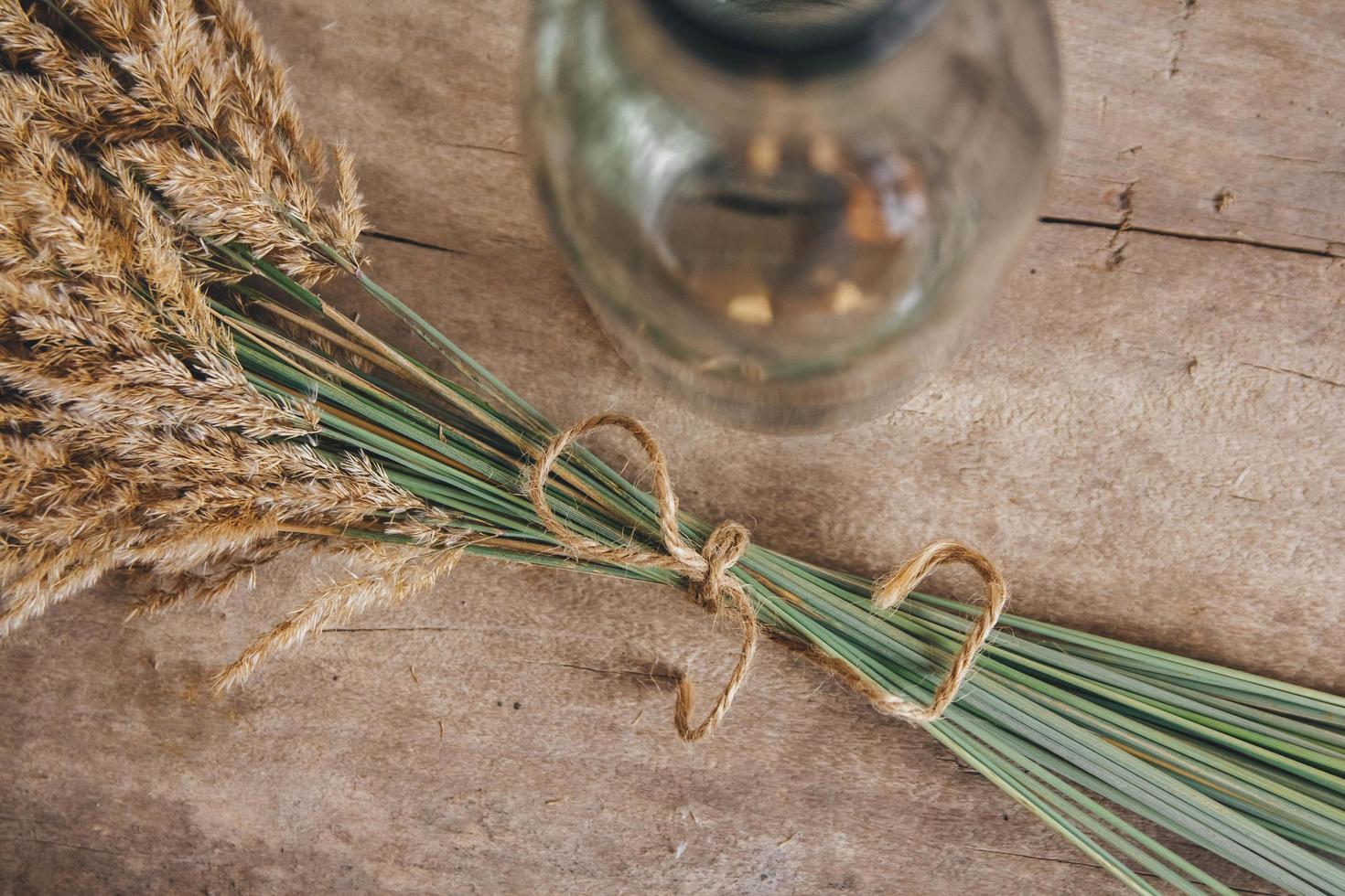 Still life of a bouquet of dried flowers in a glass bottle on a wooden table. Place for text or advertising. View from above photo