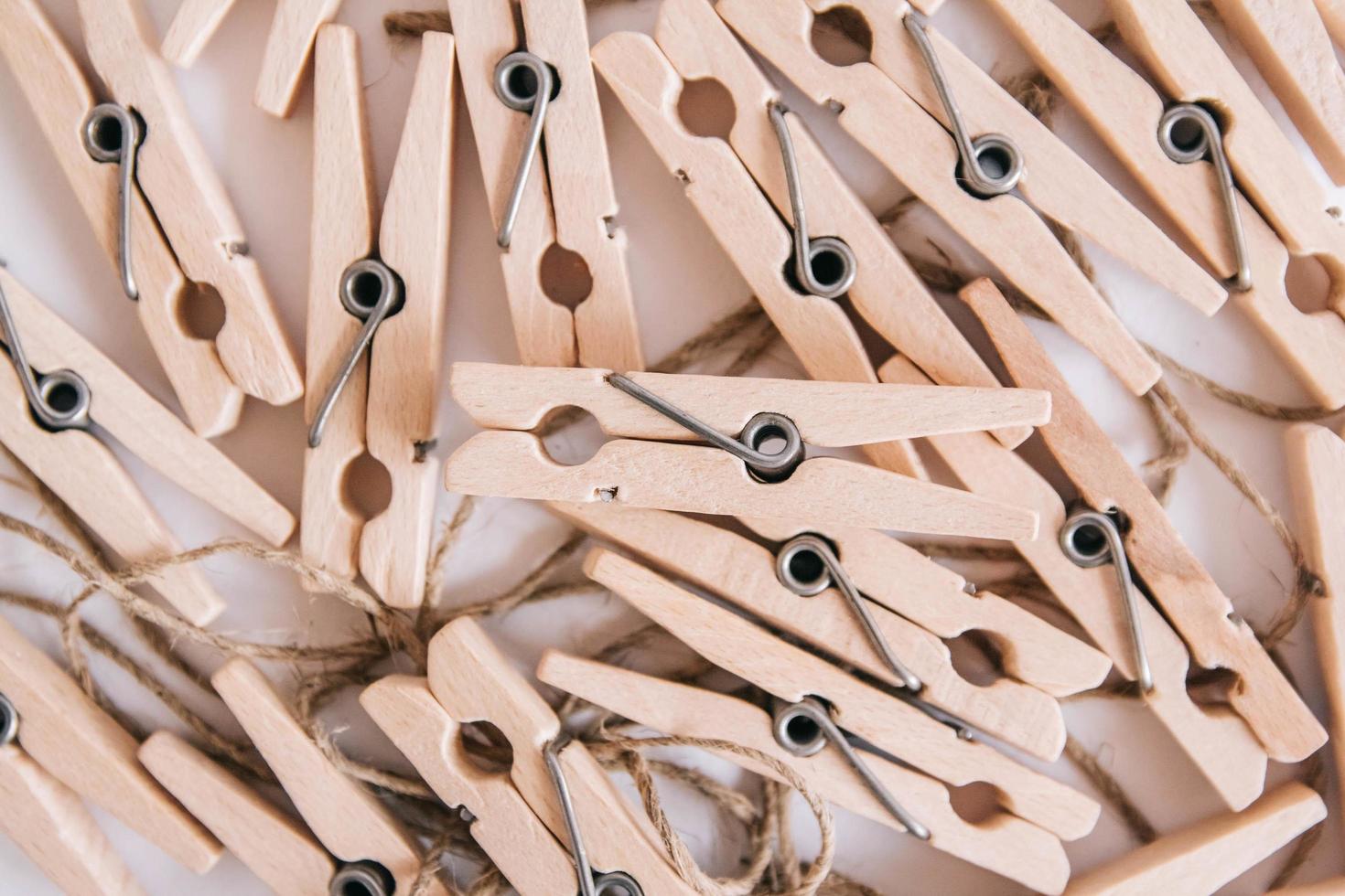 Wooden clothespins with rope on white background. View from above. Place for your text photo