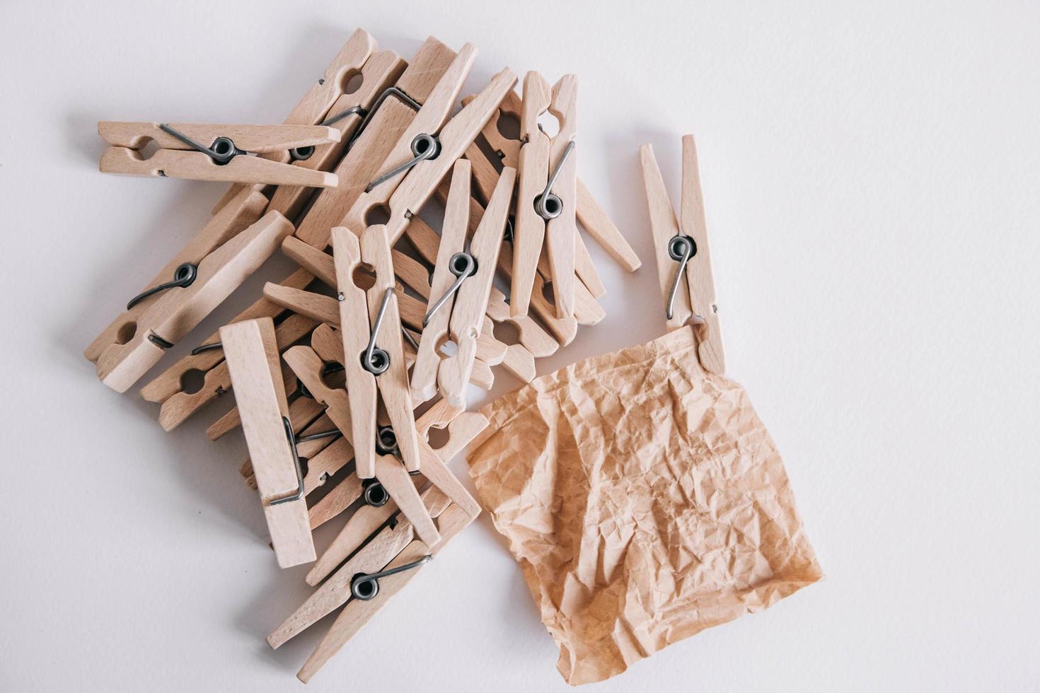 Woodenl clothespins, paper clip and brown sticker on white background. Isolated on white. View from above. Place for your text photo