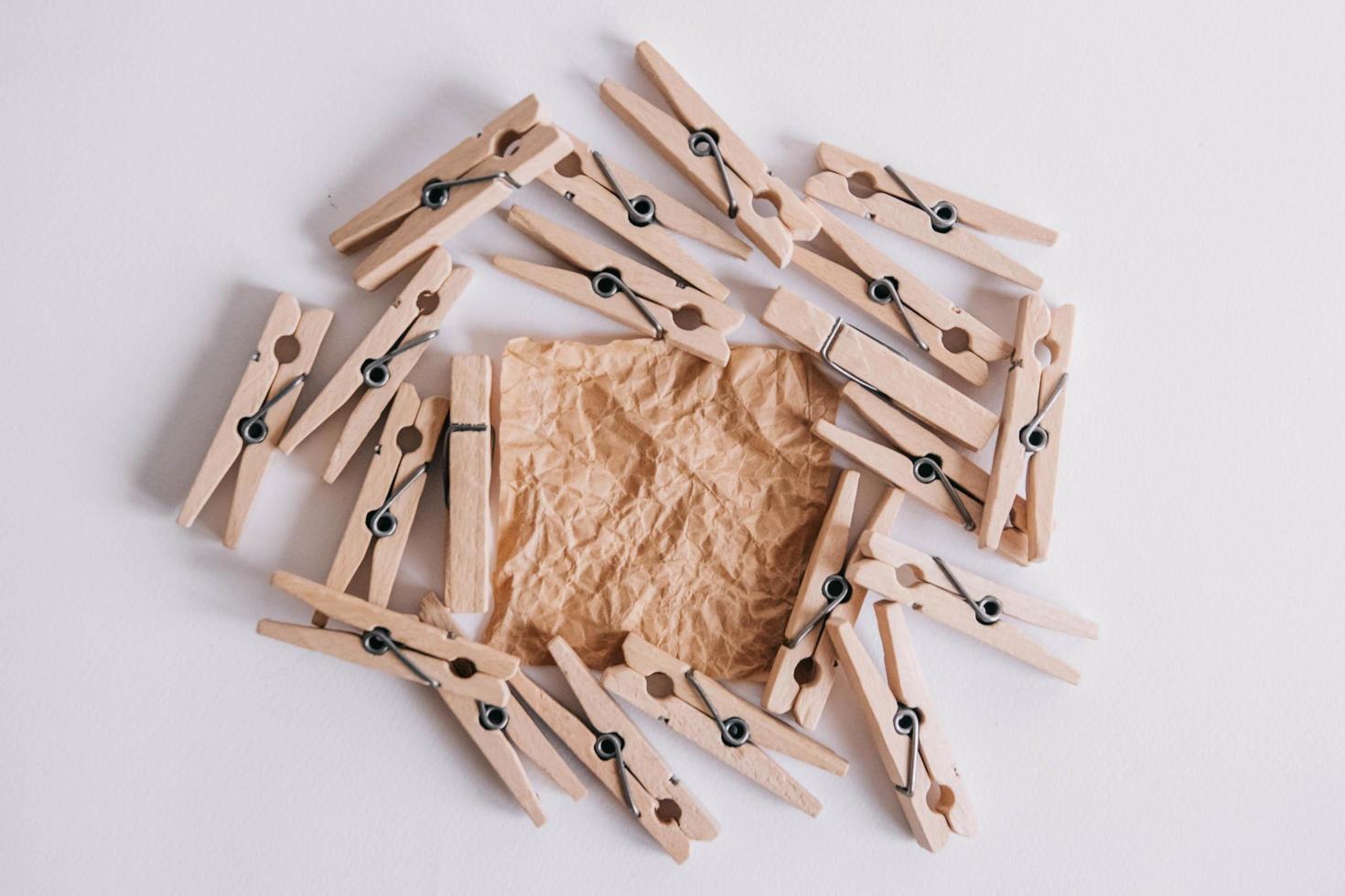 Woodenl clothespins, paper clip and brown sticker on white background. Isolated on white. View from above. Place for your text photo