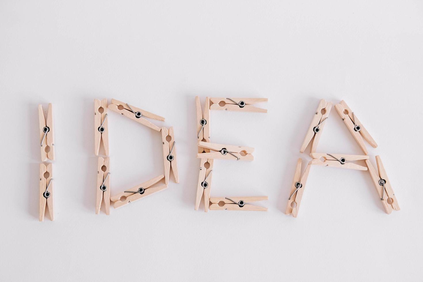 Wooden clothespins on a white background with the inscription the word idea. View from above photo