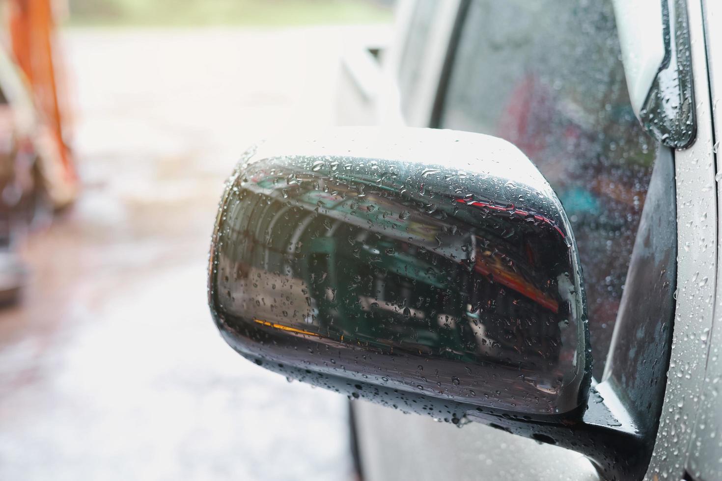 los espejos laterales están llenos de gotas de lluvia. foto