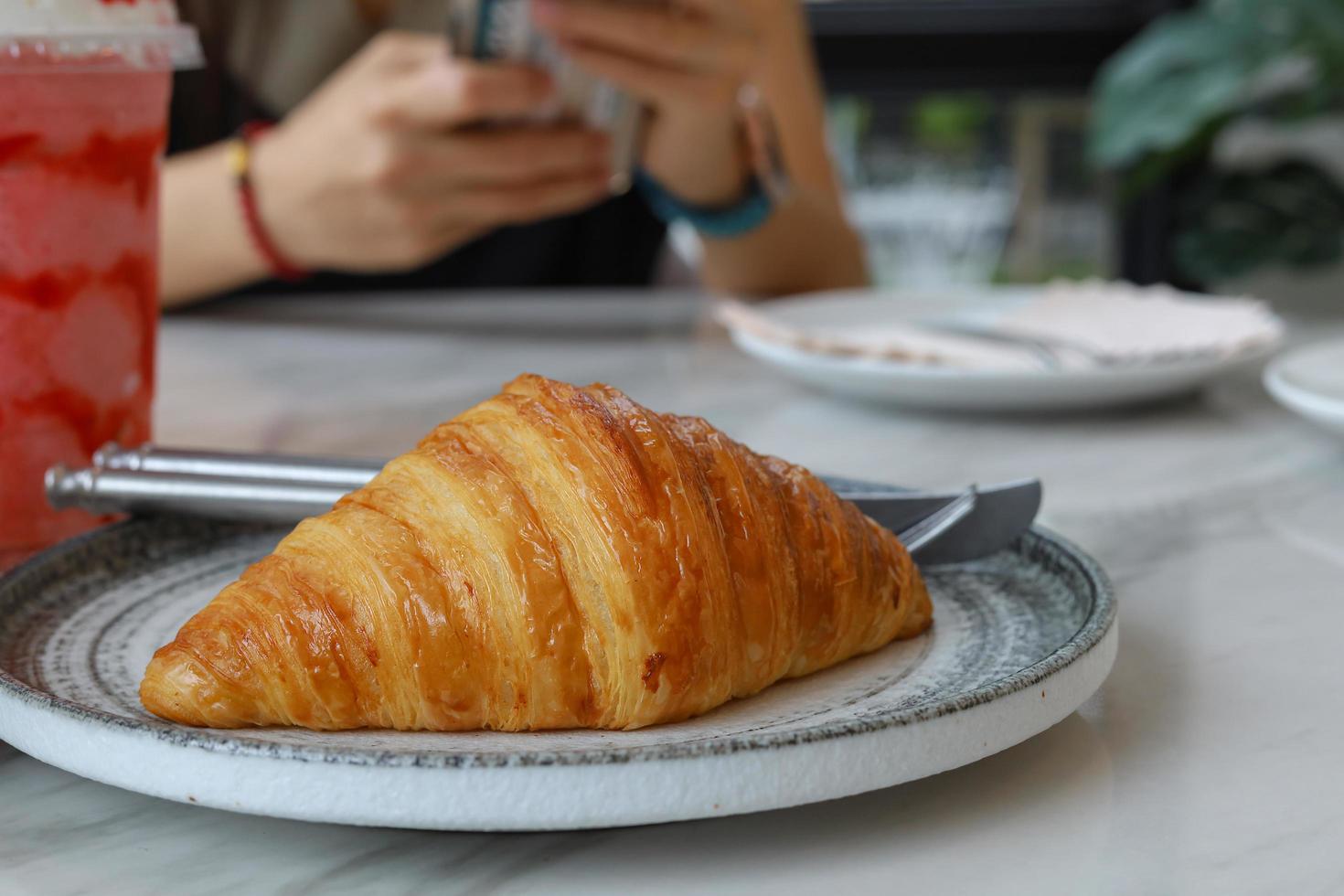 Croissant recién horneado brillante en la cafetería. foto