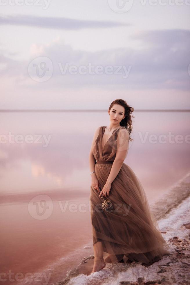 girl on the shore of a pink salt lake photo