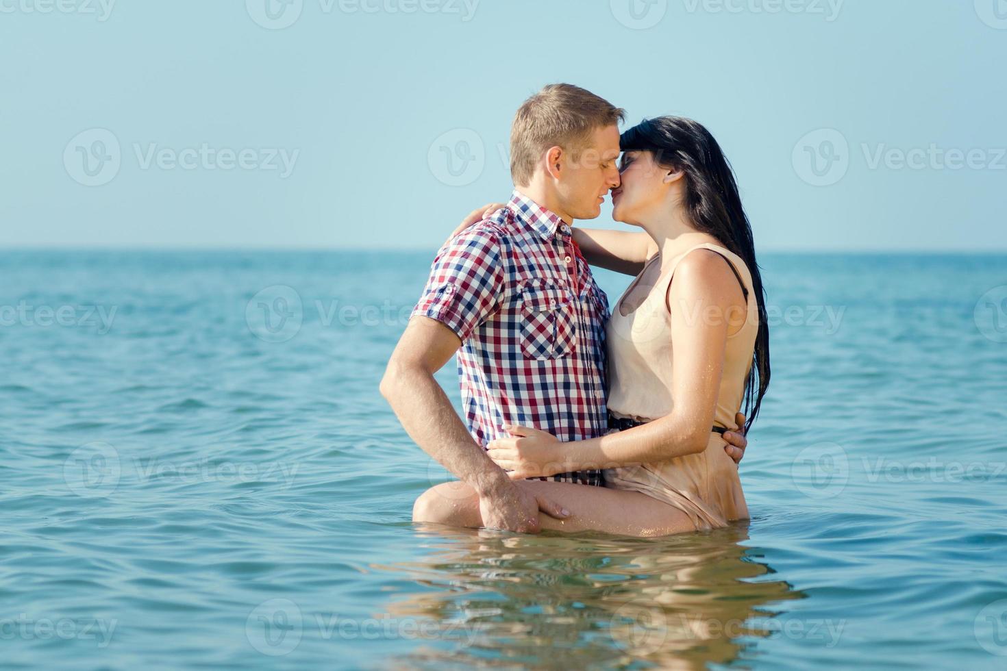 a guy and a girl walk along the seashore photo