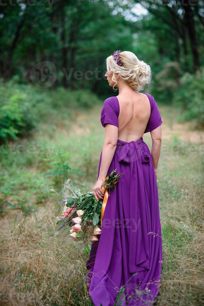 Girl model blonde in a lilac dress with a bouquet photo