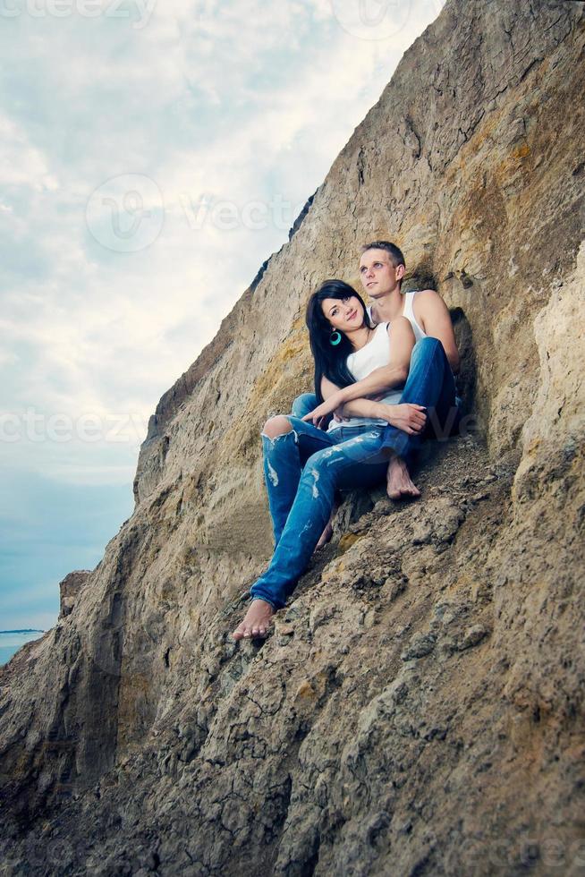 chico y una chica en jeans y camisetas blancas en la playa foto