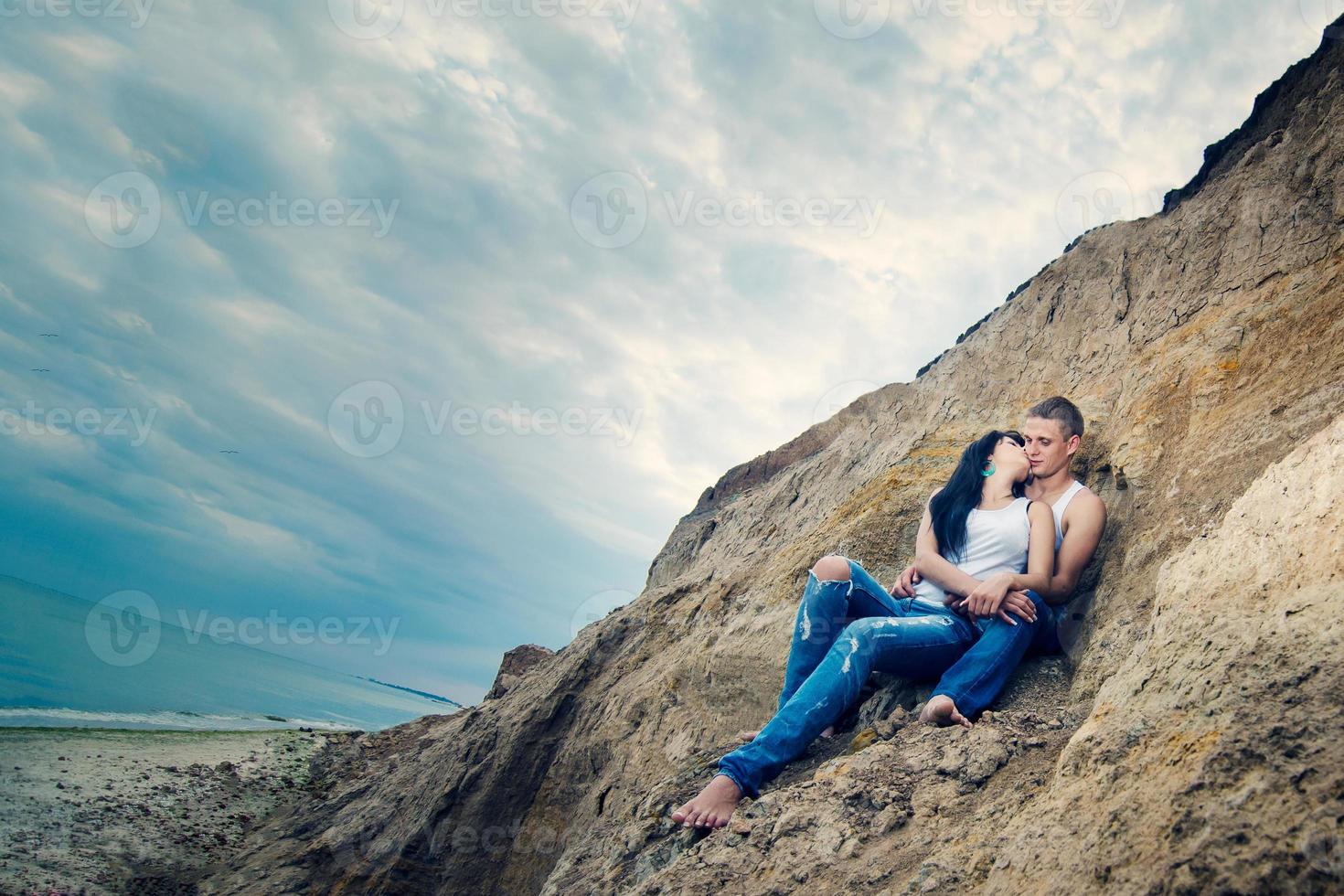 chico y una chica en jeans y camisetas blancas en la playa foto