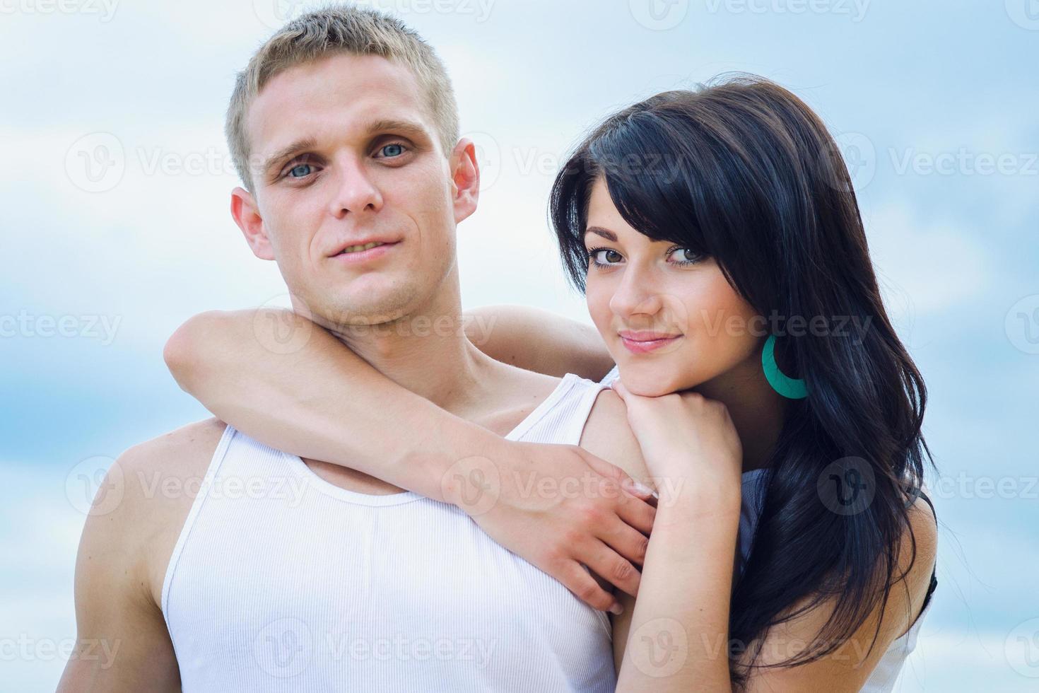 guy and a girl in jeans and white t-shirts on the beach photo