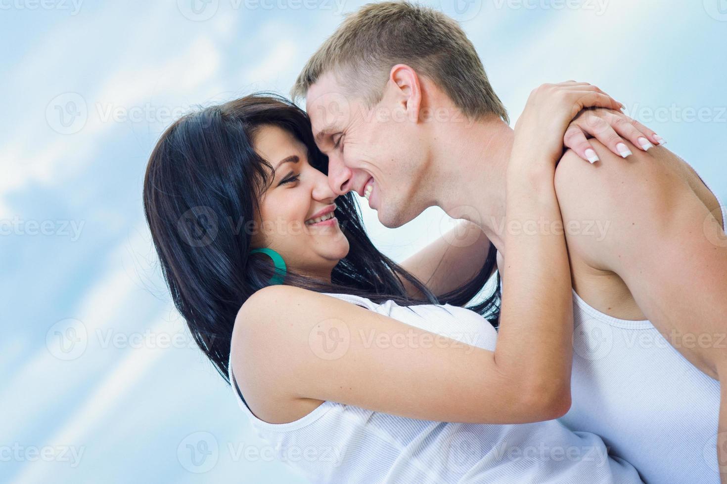guy and a girl in jeans and white t-shirts on the beach photo