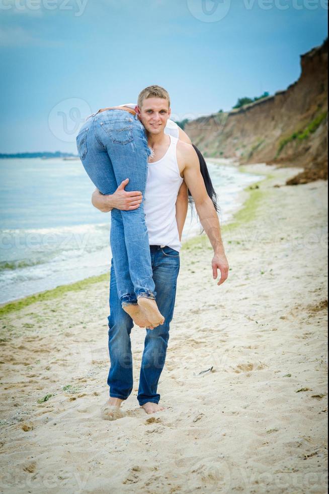 guy and a girl in jeans and white t-shirts on the beach photo