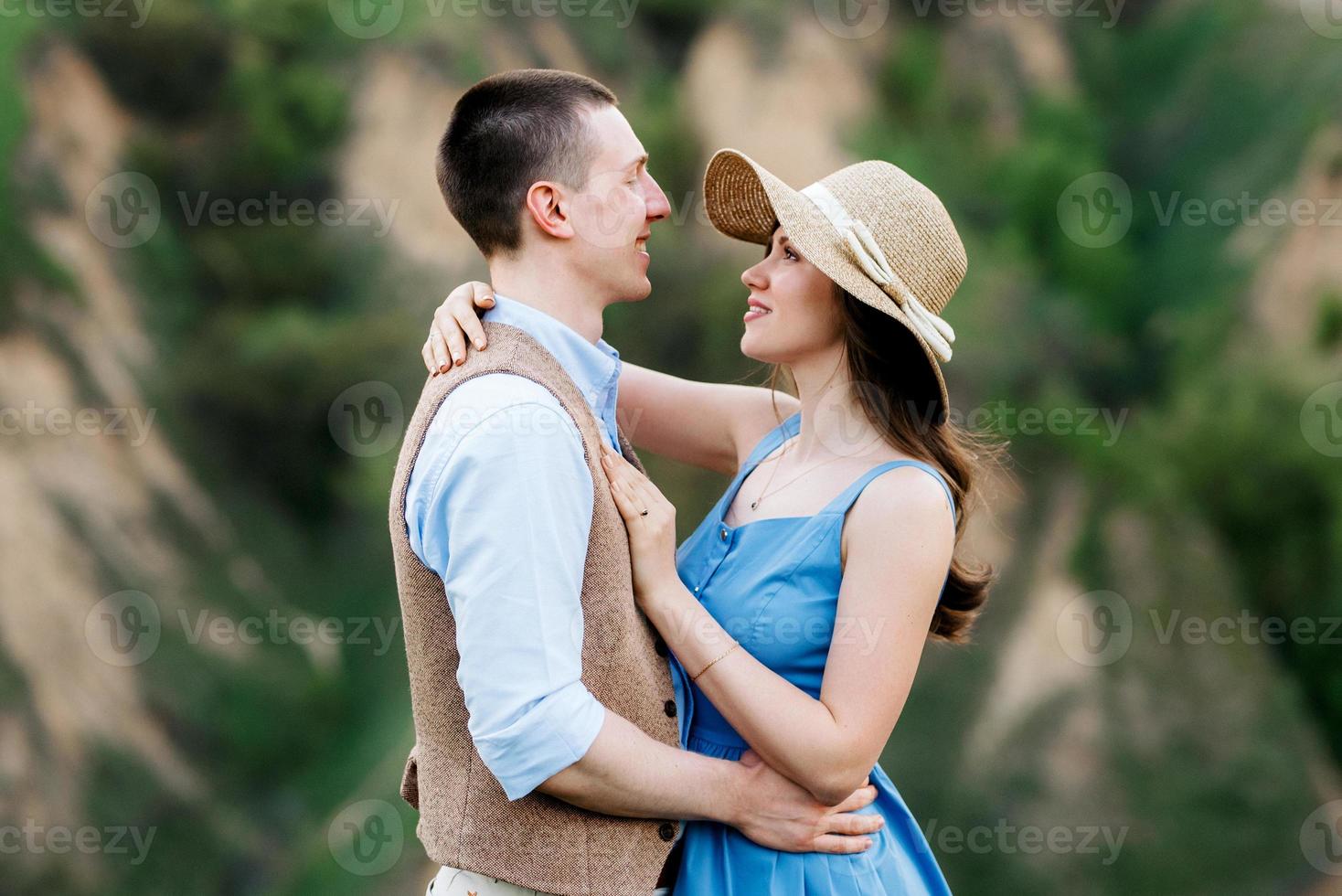 pareja joven, un chico y una chica están caminando en las colinas de la montaña foto