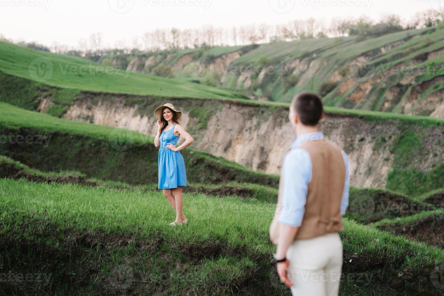 pareja joven, un chico y una chica están caminando en las colinas de la montaña foto