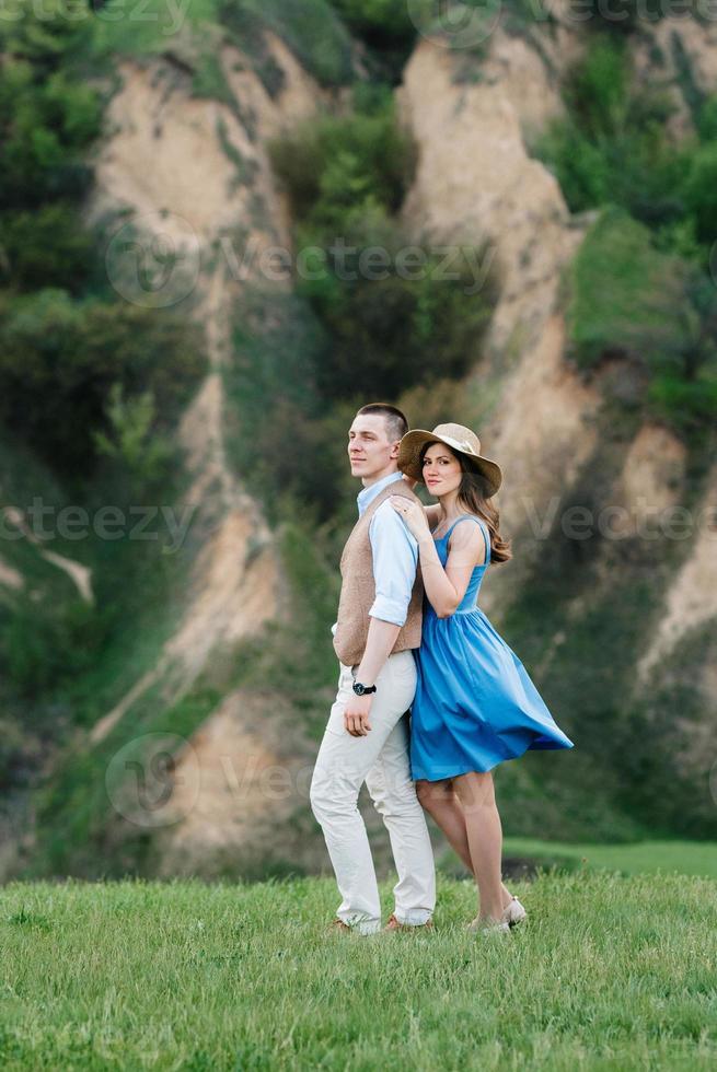 young couple a guy and a girl are walking in the mountain hills photo